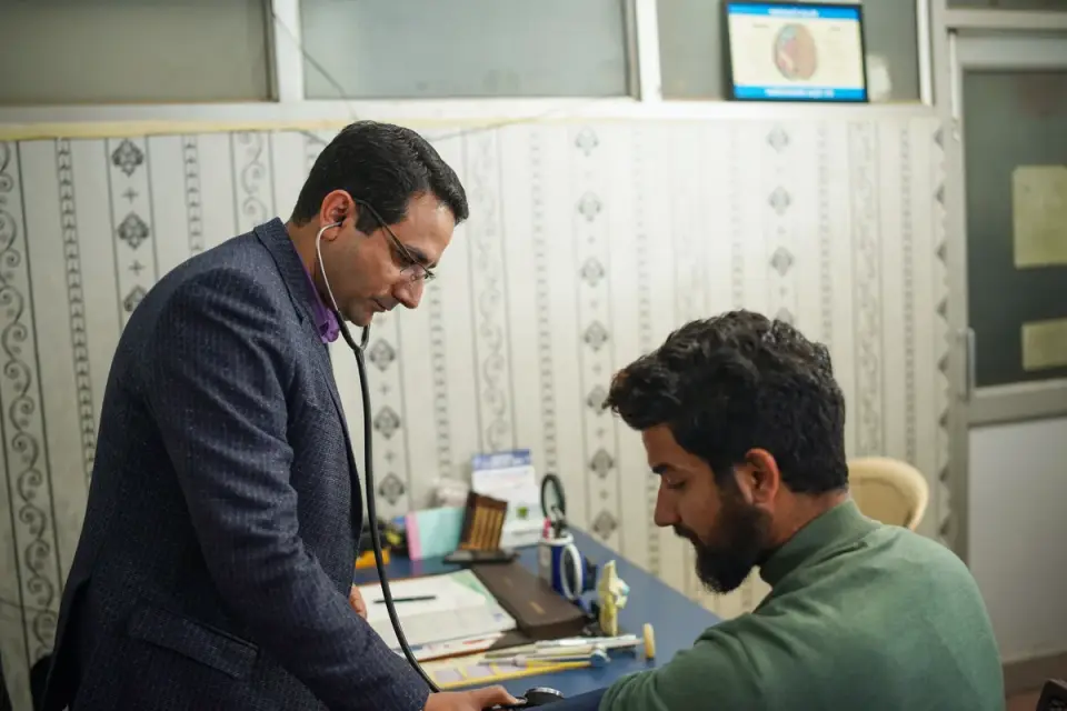 Veterinarian listening to a dog&#x27;s abdomen during an exam